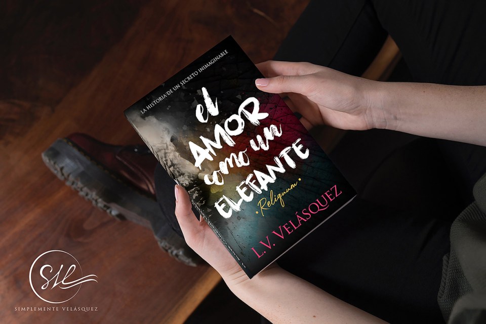 Mujer con botas sostiene "El Amor Como Un Elefante"